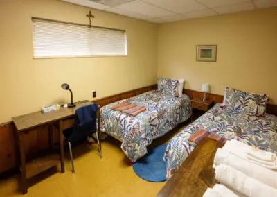 2 twin beds in a bedroom at the St. Felix Lodge at Maryville Retreat Center in Holly, Michigan