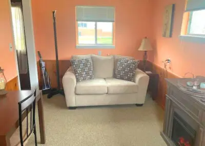 Couch in an orange room at the LaVerna Hermitage lodge, a cozy retreat for up to 2 guests seeking a place to stay in Holly, Michigan.