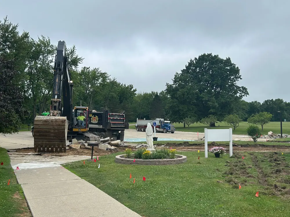Construction work underway in the parking lot of Maryville Retreat Center, with equipment and workers preparing the area.