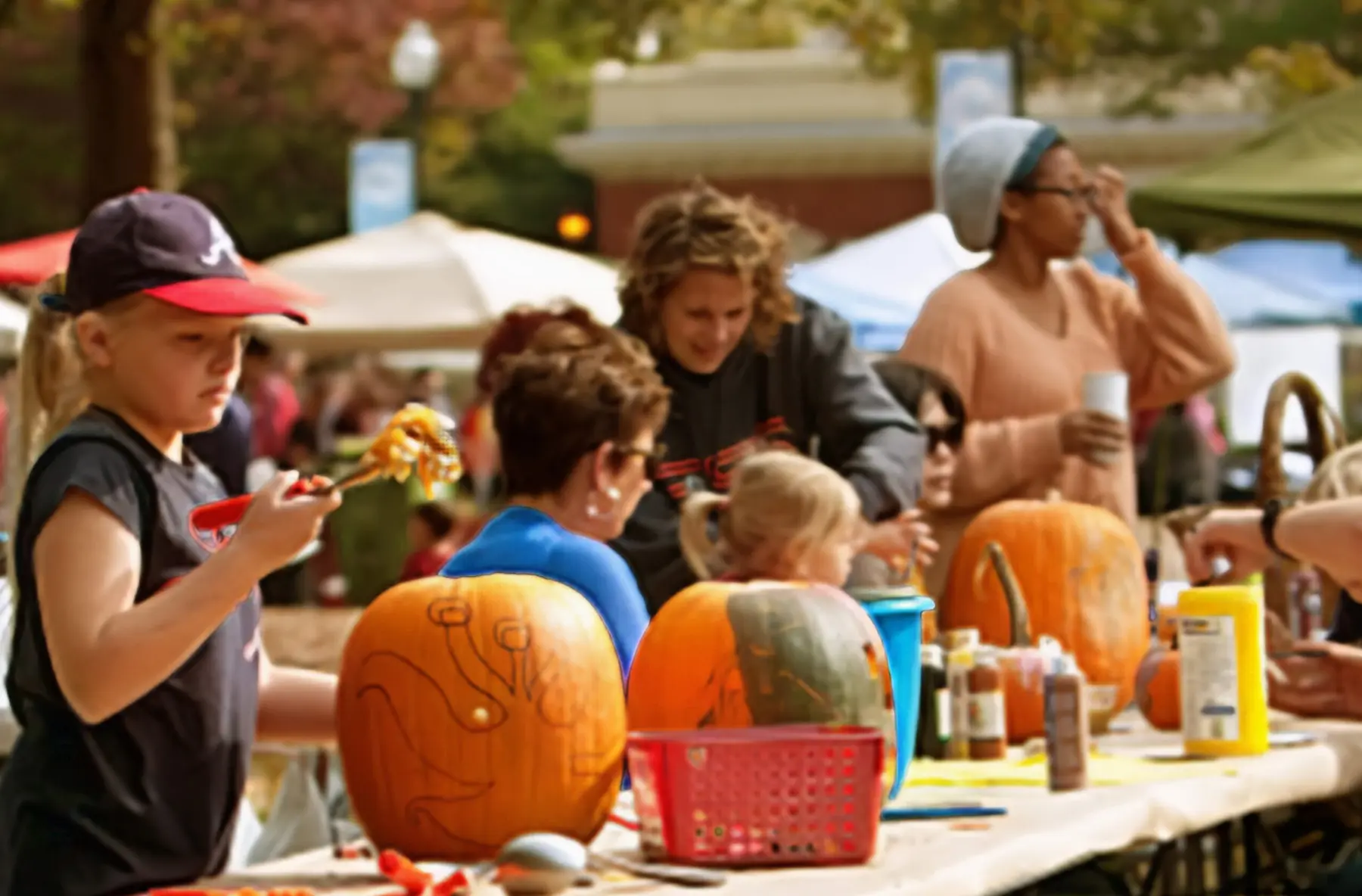 Group of kids carving pumpkins at a Fall Festival