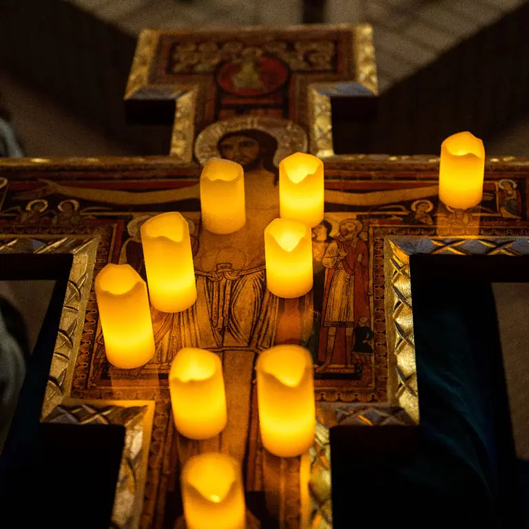 Taizé prayer program set up with a cross and candles.