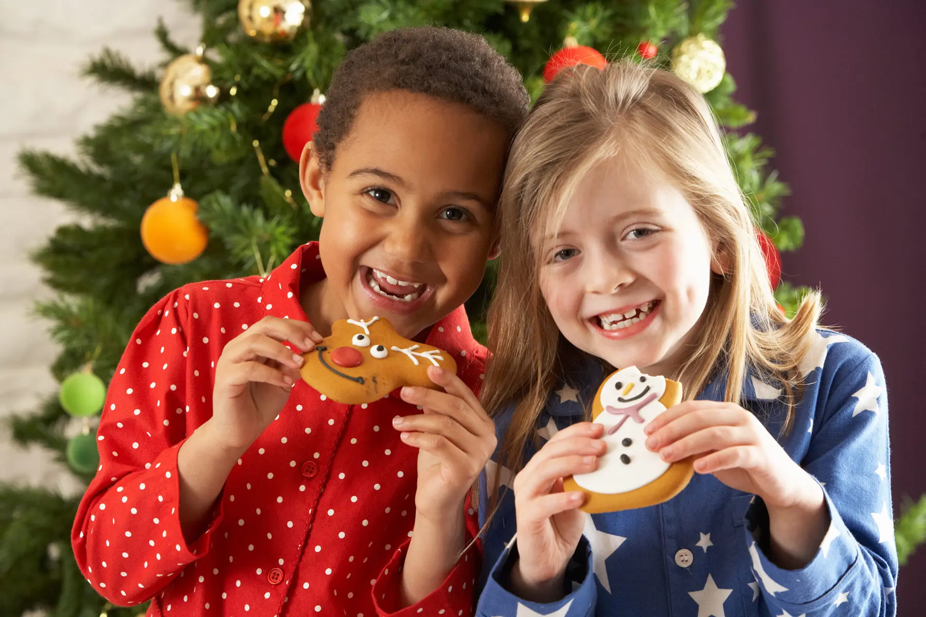 Two children holding Christmas cookies during Brunch with St. Nicholas.