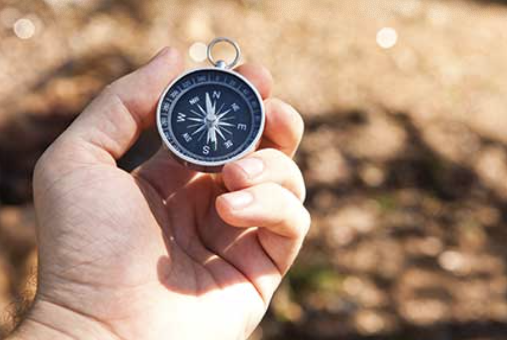 Compass held in a hand, symbolizing guidance and discernment during the spiritual direction retreat.